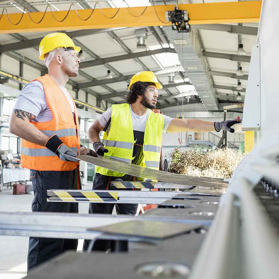 Two Employees Working at a Metal Shop Two Employees Working at a Metal Shop